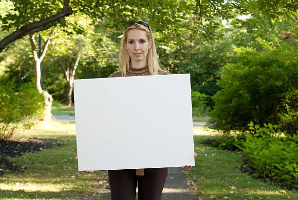 istock Woman in Park Holding Blank White Sign 123878031