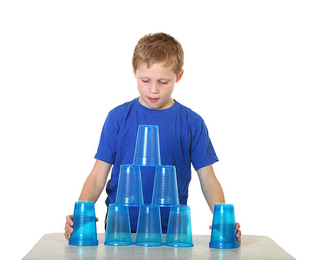 garçon avec des coupes - cup child geometric shape stacking photos et images de collection