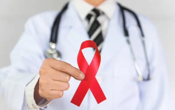 Doctor Holds Red Ribbon to awareness world aids day Dec. 1