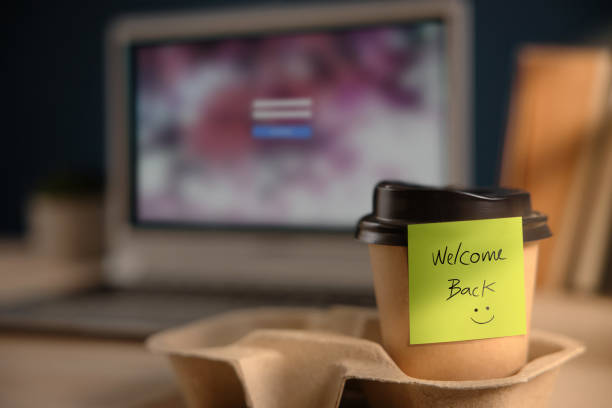 istock Back to Work Concept. Closeup of Welcome Note on Takeaway Coffee Cup in Office Desk. Message from a Colleague or Boss 1238922022