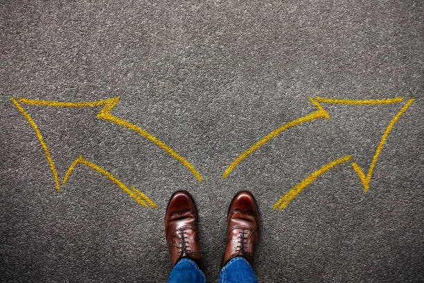 Decision in Life or Business Concept. Separates the Left and Right by two Arrow Direction. Top View of a Young Man with Brown Wingtips Shoes and Jeans Standing on the Grunge Floor