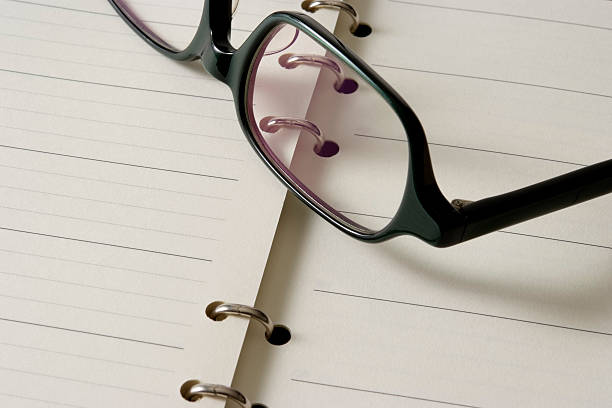 istock Close-up of opened personal organizer with glasses 123893773