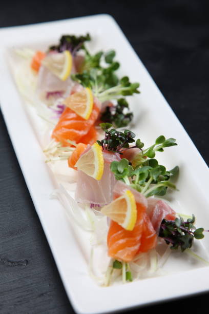 red snapper and salmon carpaccio red snapper and salmon carpaccio on dark background salmon and red snapper stock pictures, royalty-free photos & images