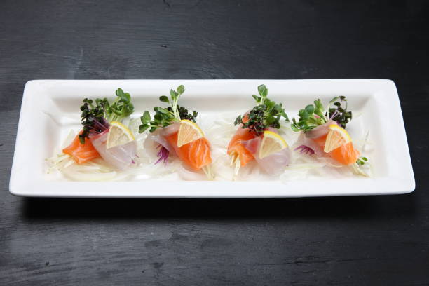 red snapper and salmon carpaccio red snapper and salmon carpaccio on dark background salmon and red snapper stock pictures, royalty-free photos & images