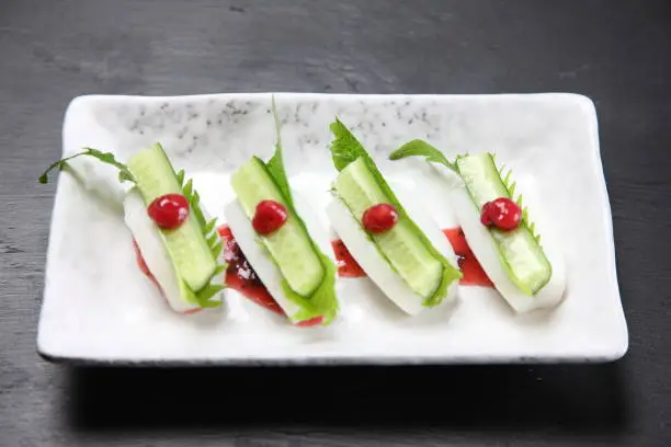 Japanese steamed fish paste with cucumber on dark background