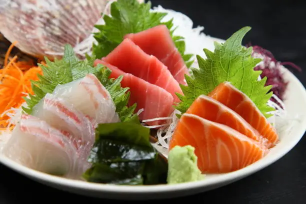 seasonal fresh sashimi asorted plate on dark background