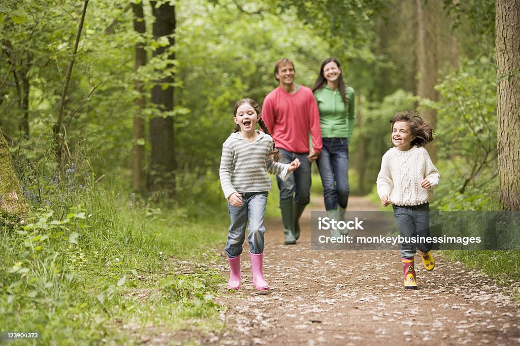 Happy family walking on a path in the woods Family walking on woodland path smiling Family Stock Photo