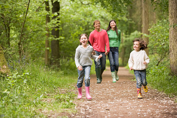 szczęśliwa rodzina walking na ścieżki w lesie - family walking child park zdjęcia i obrazy z banku zdjęć