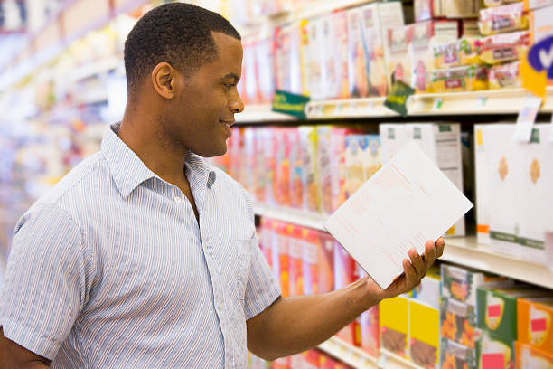 istock Man holding and looking at cereal box in shopping aisle 123904412