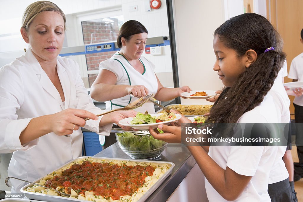 Aluna segurando o prato do almoço no refeitório da escola - Foto de stock de Cantina royalty-free