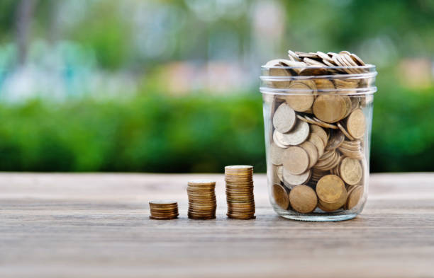 istock Coin stairs and jar on wooden table 1239105183