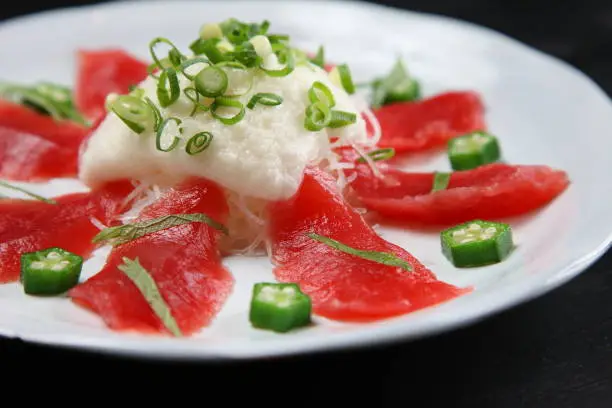 fresh tuna with yam carpaccio on dark background