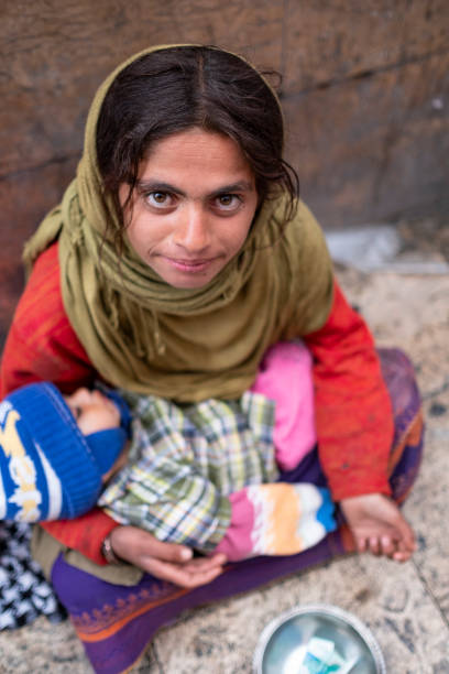 가난한 여동생을 들고 있는 파우퍼 무슬림 소녀는 돈을 구걸하고 있다. - pauper 뉴스 사진 이미지