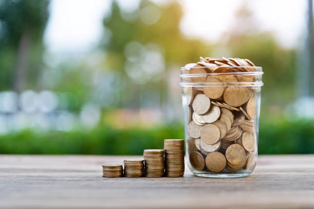 istock Coin stairs and jar on wooden table 1239110333