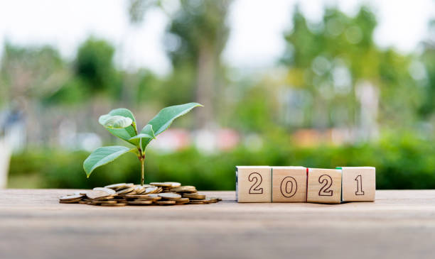 istock Coin jar and number 2021 on the table 1239115365