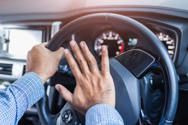 istock Hand man pushing car horn while driving car. 1239118896