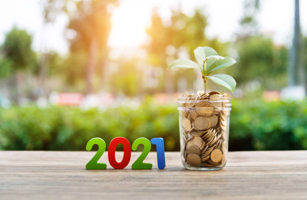 istock Coin jar and number 2021 on the table 1239126414