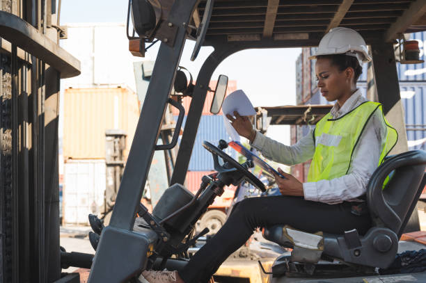 istock Black foreman woman worker driving forklift checking at Container cargo harbor to loading containers and has a problem. African depressed dock female staff business Logistics import export shipping concept. 1239158213