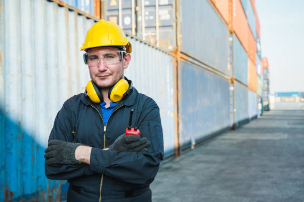 istock Foreman worker working checking at Container cargo harbor holding radio walkie-talkie to loading containers. Dock male staff business Logistics import export shipping concept. 1239169018