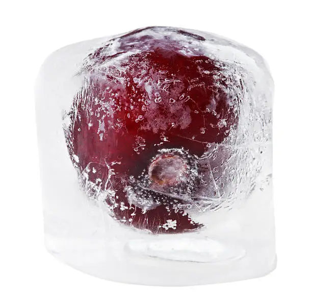 Red sweet cherry inside of melting ice cube, isolated on white