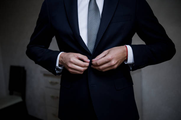 istock man puts on a suit in the room 1239177503