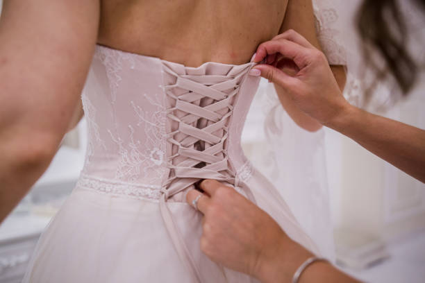 istock bride puts on a wedding dress 1239186024