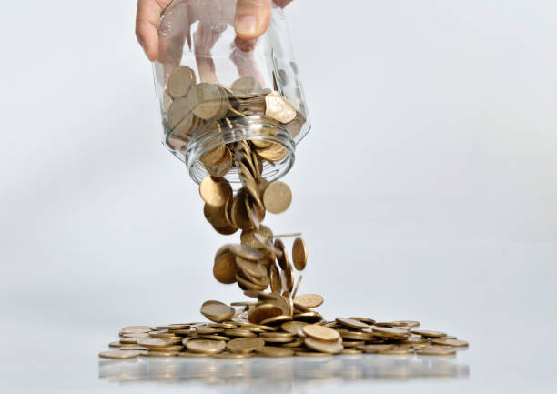 istock Coins pouring from a glass jar 1239186538