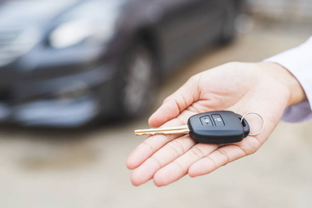 istock Businessman giving a car key. Getting new car. 1239197683