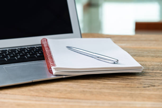 istock Laptop with pen and notepad on the desk 1239208787
