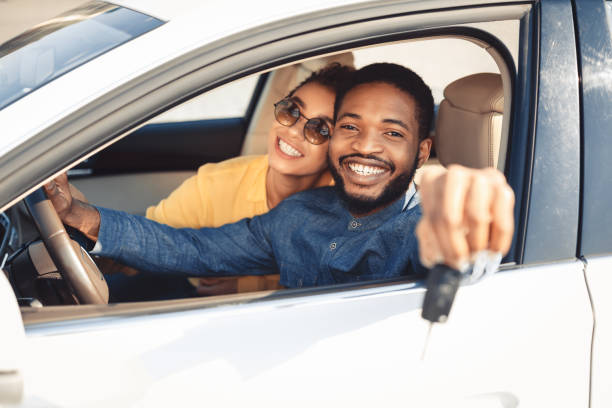自動車に座っている新しい車のキーを示すアフリカ系アメリカ人の配偶者 - car african descent shopping car dealership ストックフォトと画像