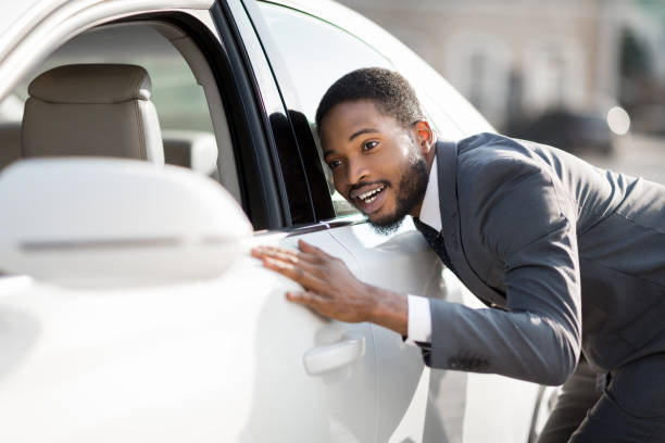 istock Black Businessman Checking And Touching His New Automobile Outside 1239227454