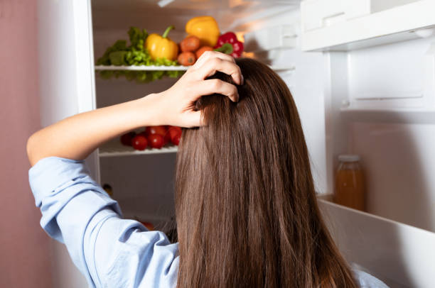 istock Housewife thinking what to cook, looking at open fridge 1239230095