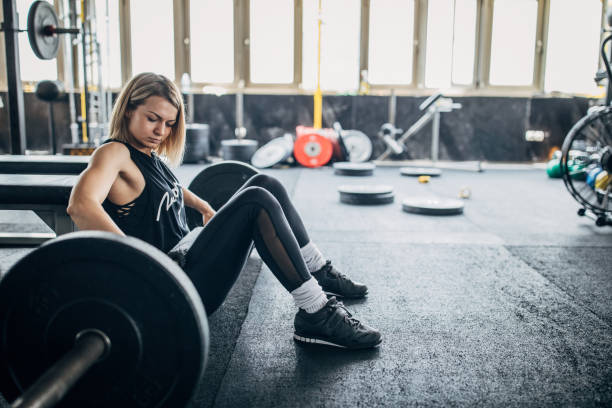 istock One young woman exercise with barbell in the gym 1239233302