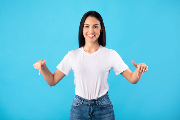 istock Happy woman pointing fingers down at copy space 1239237548