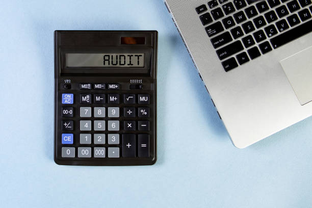 istock Calculator text AUDIT and laptop on the blue background. Top view. 1239238588