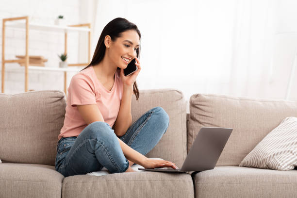 istock Woman talking on mobile phone sitting on sofa 1239248936