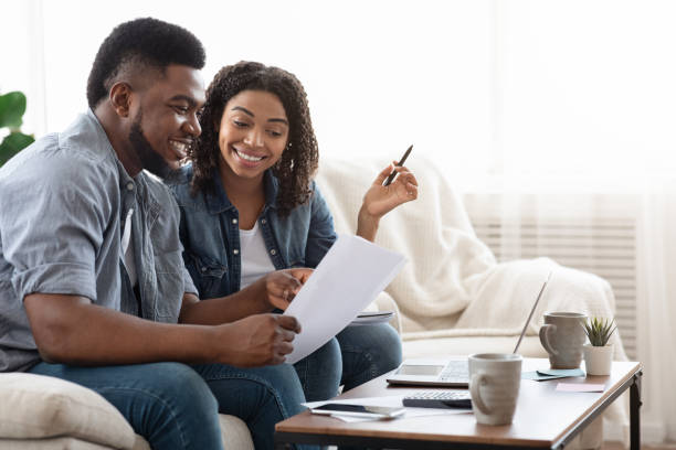 istock Young african american spouses checking documentation at home, reading insurance agreement 1239249456