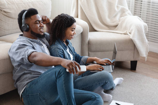 istock Relaxed Guy Listening Music At Home While His Girlfriend Working On Laptop 1239252592