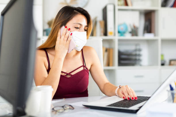 istock Young  peruvian woman manager in mask using phone 1239255239