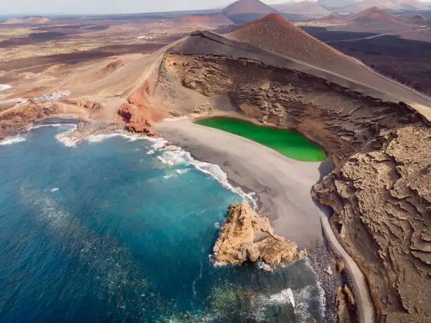 Photo of Volcanic crater with a green lake in El Golfo, Lanzarote, Spain. Aerial view