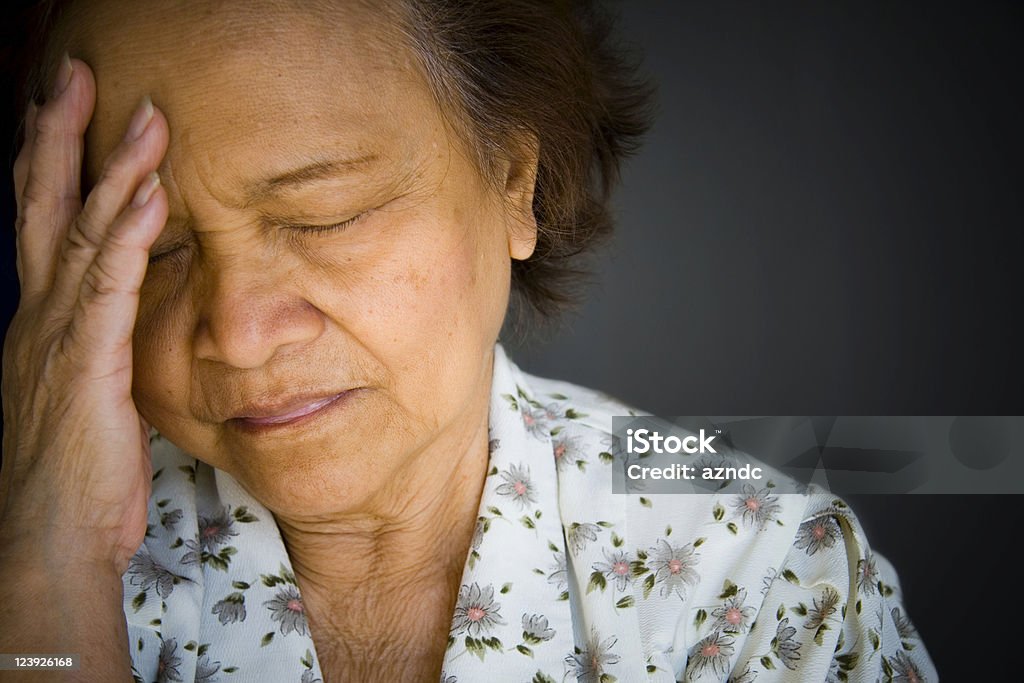 Distraught, pained older woman, eyes closed, hand to brow Elderly Asian woman, shallow depth of field.  Image exclusive to iStockphoto. Depression - Sadness Stock Photo