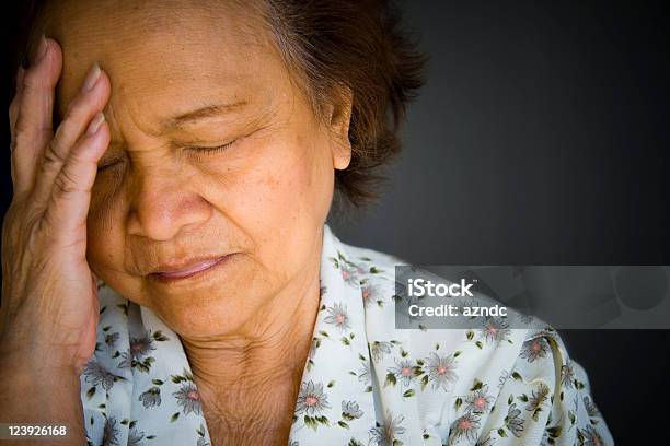 Distraught Pained Older Woman Eyes Closed Hand To Brow Stock Photo - Download Image Now