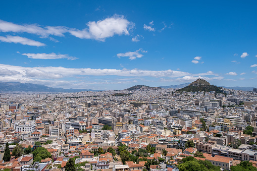 Mount Lycabettus and Athens cityscape aerial photo,  view from Acropolis hill in Greece. Blue sky with clouds, sunny spring day.