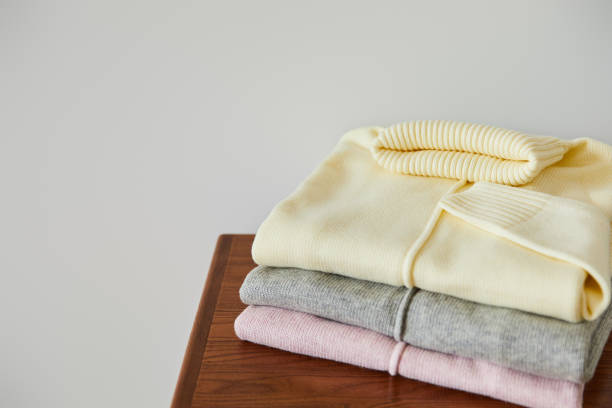 istock pink, beige and grey knitted soft sweaters on wooden table isolated on white 1239308465