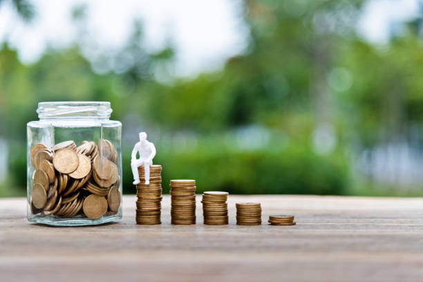 istock Coin stairs and jar on wooden table 1239308987