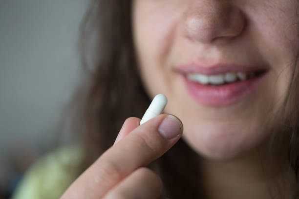 istock Woman is putting supplements in her mouth. 1239319959