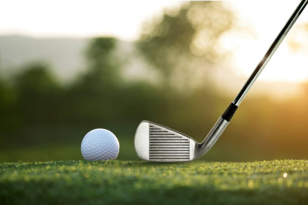 tacos de golfe e bolas de golfe em um gramado verde em um belo campo de golfe com sol da manhã - golf golf flag sunset flag - fotografias e filmes do acervo