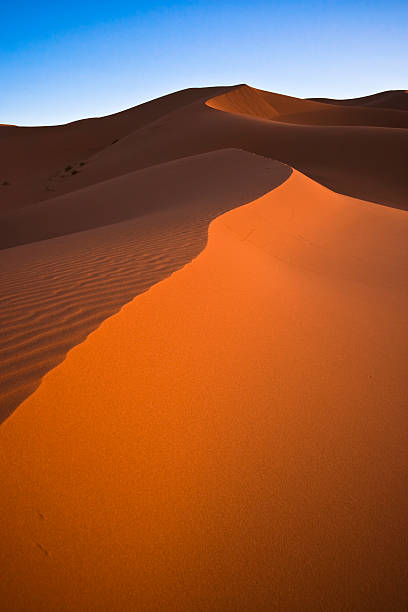 пустыня сахары дюны песка против голубого неба. - landscape desert wave pattern erg chebbi dunes стоковые фото и изображения