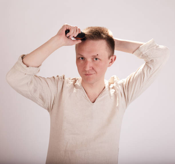 istock Man doing haircut by himself at home while Covid-19 quarantine. Self isolation lifestyle 1239348560