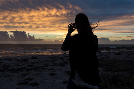 Young Woman Taking Photos of Magnificent Sunset View
